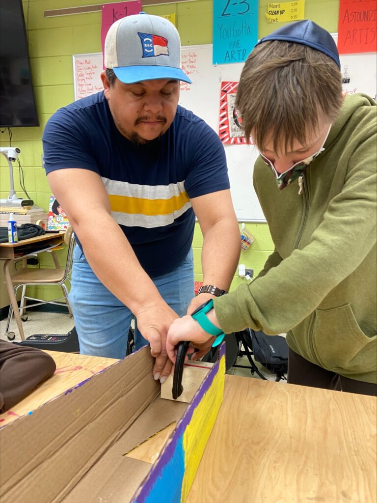 Larry with Student making cardboard base of a harp